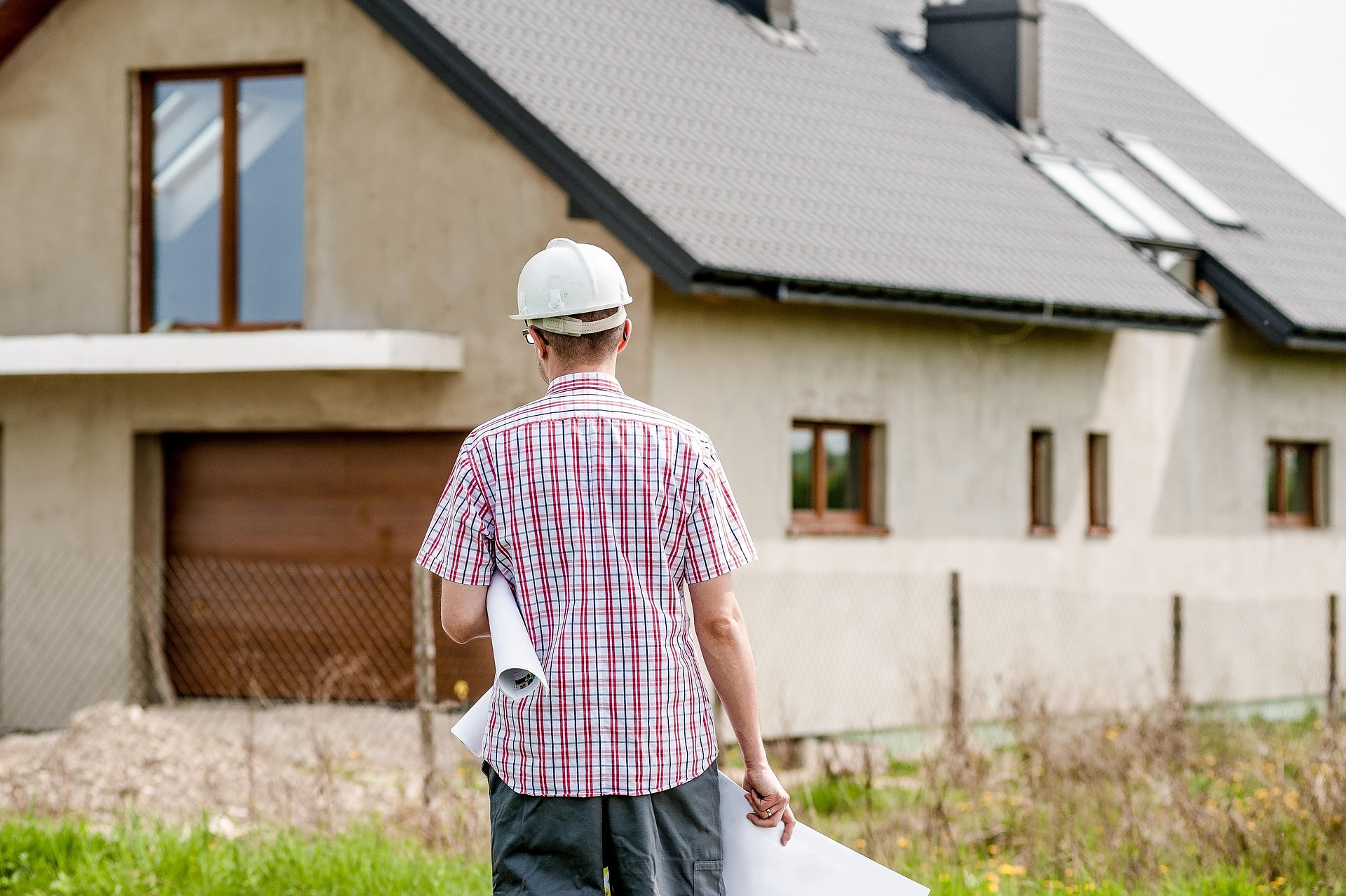 Architekt vor einem Einfamilienhaus.